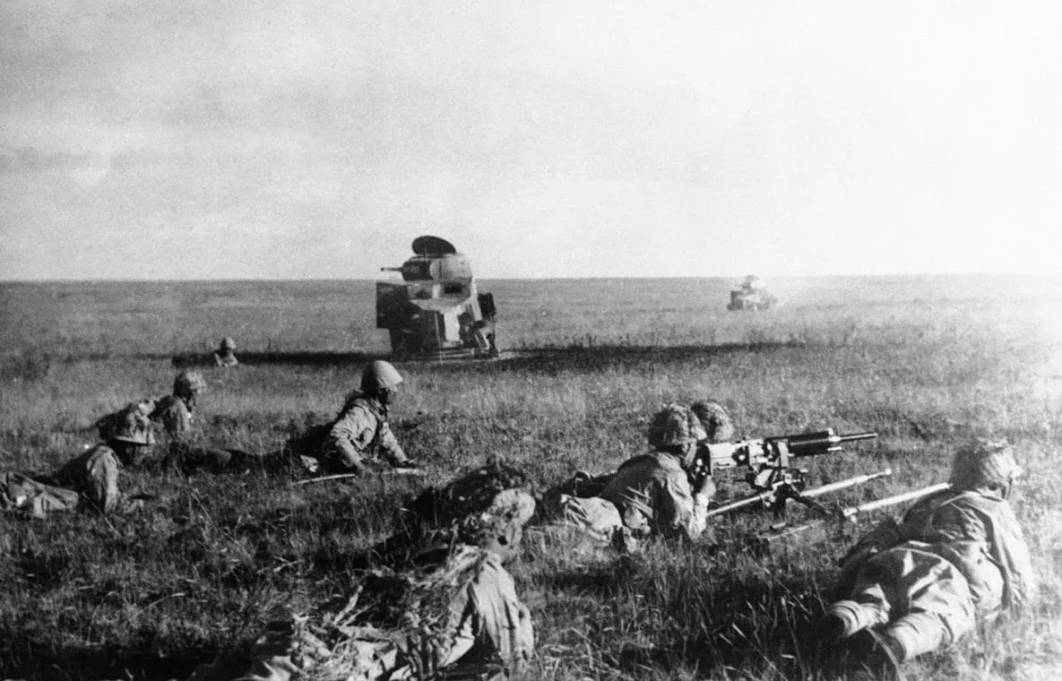Japanese soldiers creep in front of wrecked Soviet armoured cars, July 1939.