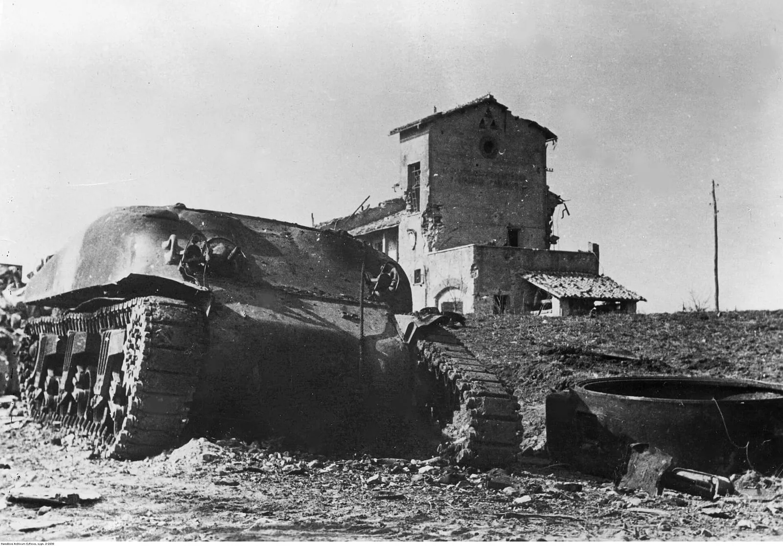 A turretless Sherman M4A1 tank at the front near Nettuno–Anzio, February 1944, with ruined buildings behind.