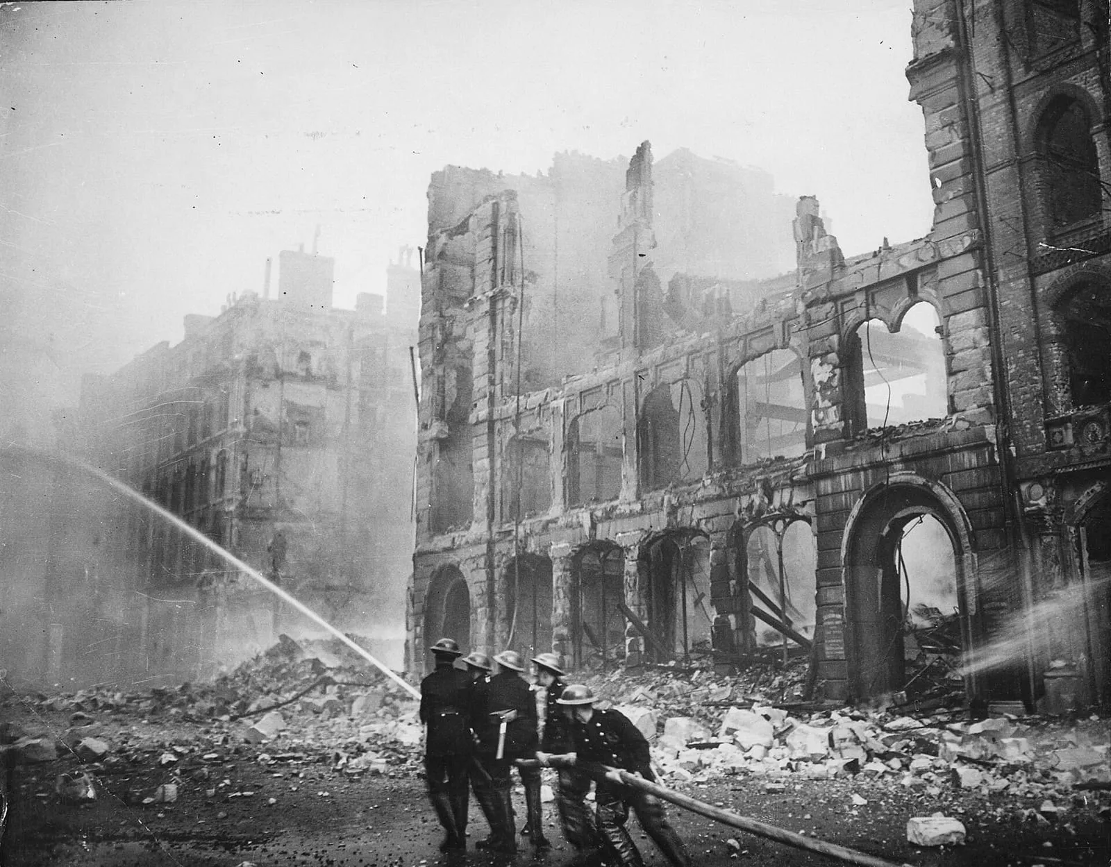 Firefighters putting out a blaze in London after an air raid during the Blitz, c. 1941.
