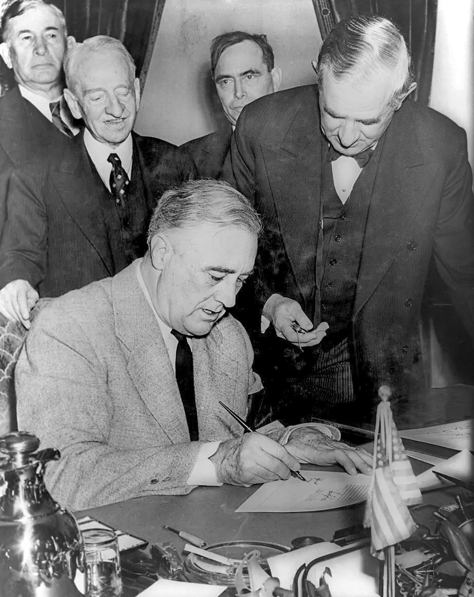 President Roosevelt signs the declaration of war against Germany, 11 December 1941.