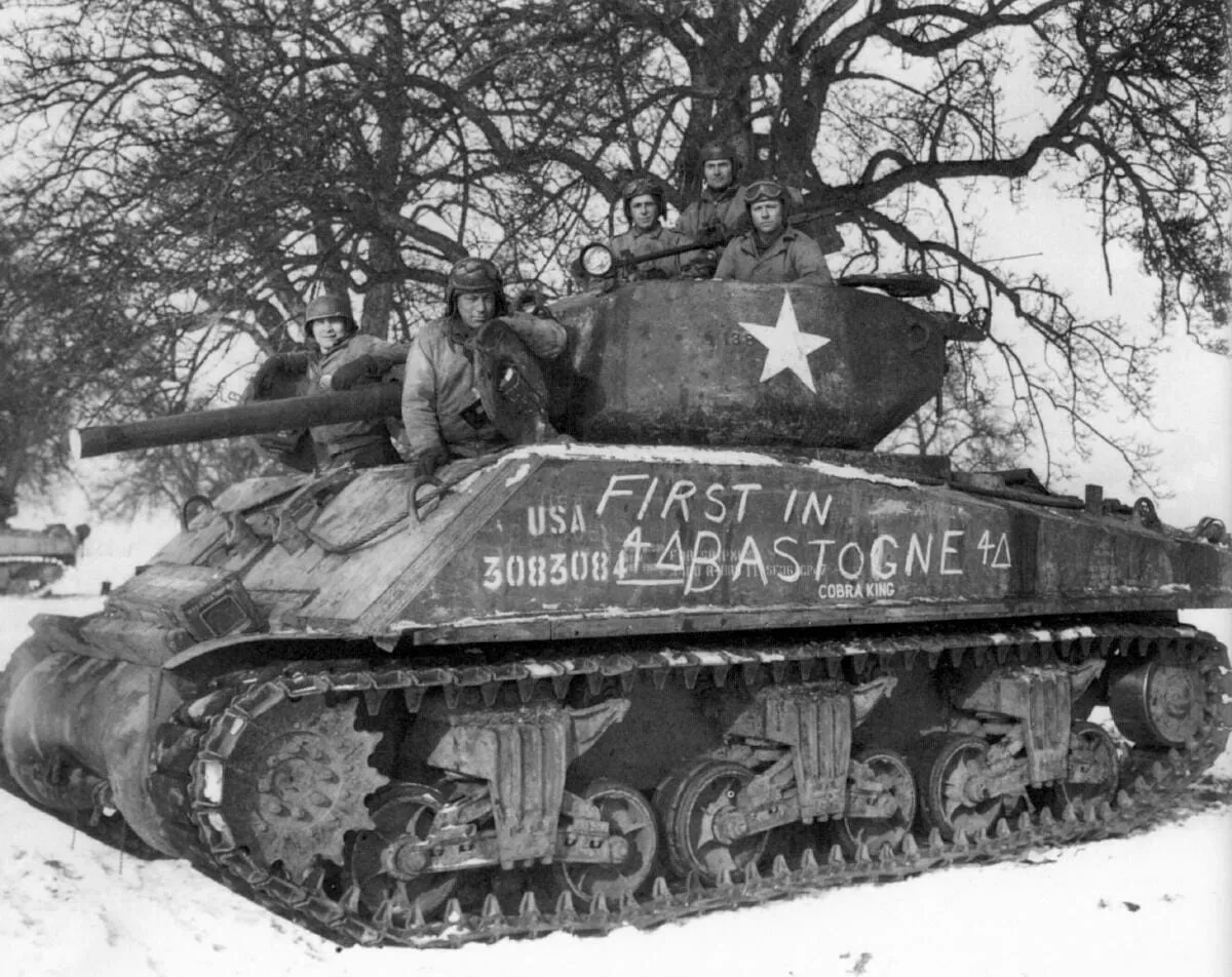 The crew of the “Cobra King” tank pose for a celebratory photo near Bastogne, shortly after the tankers led the column that liberated the city in December 1944.