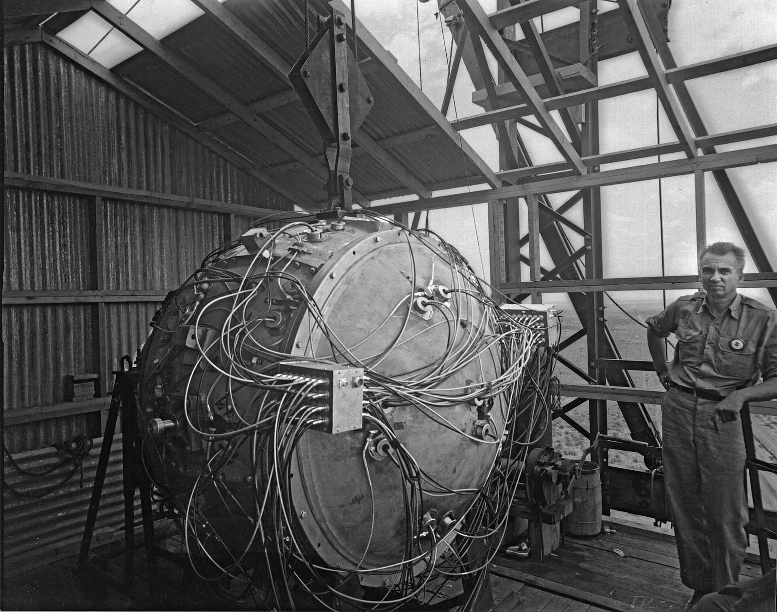 Norris Bradbury stands next to the partially assembled “Gadget” atop the test tower, 15 July 1945.