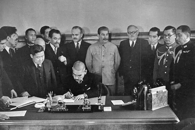Matsuoka signs the Soviet–Japanese Neutrality Pact in the presence of Stalin and Molotov.