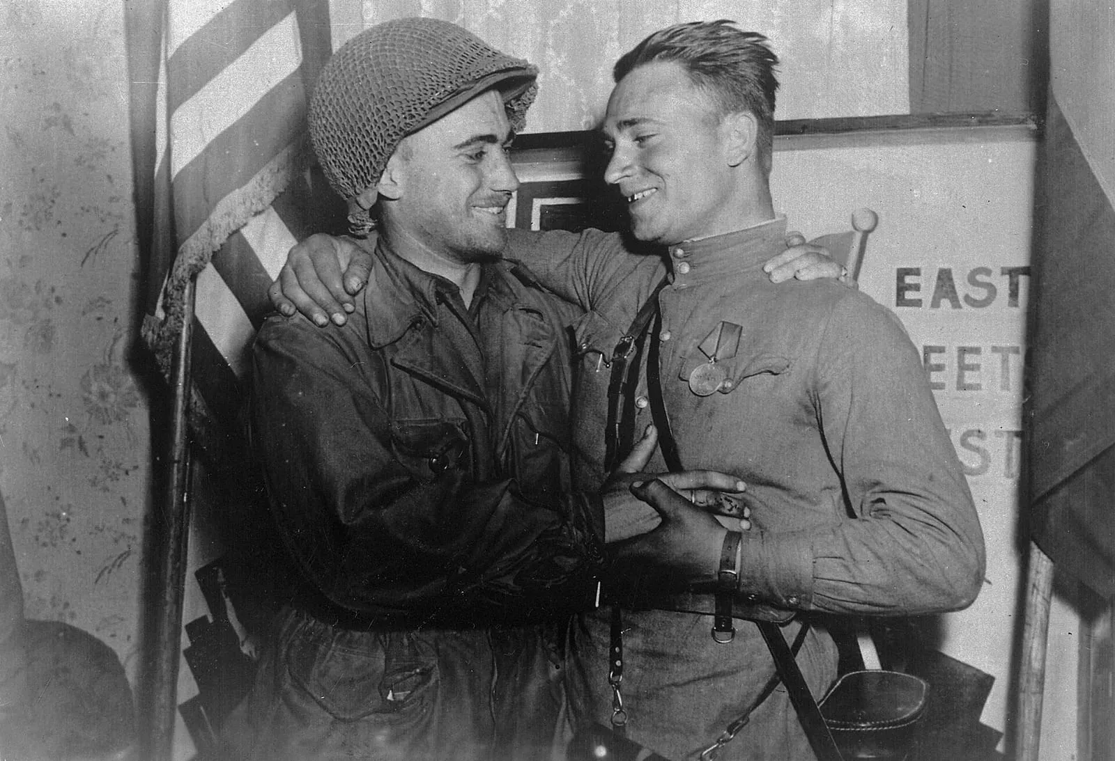 Lt. William Robertson of the U.S. Army and Lt. Alexander Silvashko of the Red Army in front of a sign marking the meeting of the two armies near Torgau.