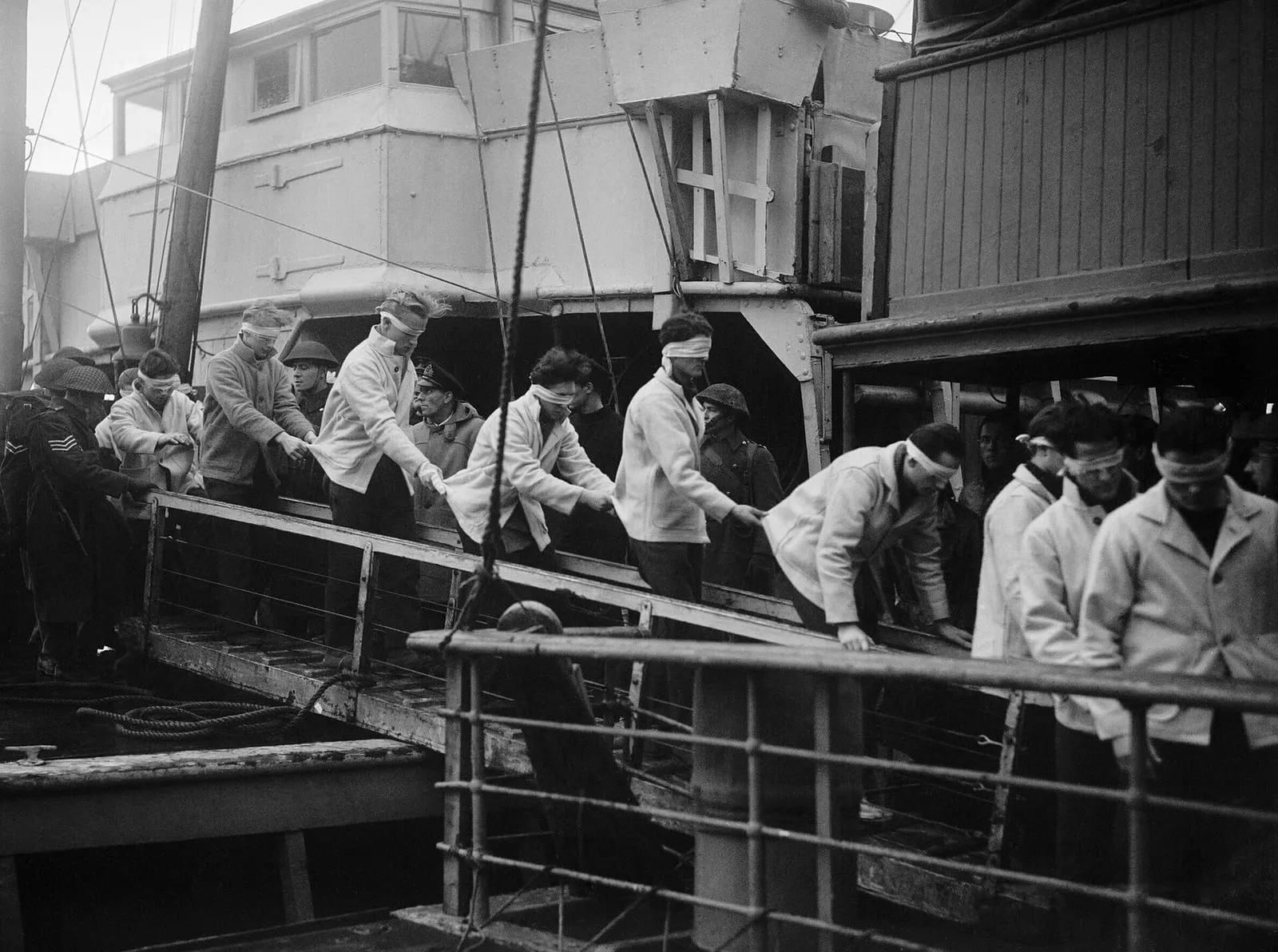 Blindfolded survivors of the Scharnhorst walking down a gangway at Scapa Flow, 2 January 1944.