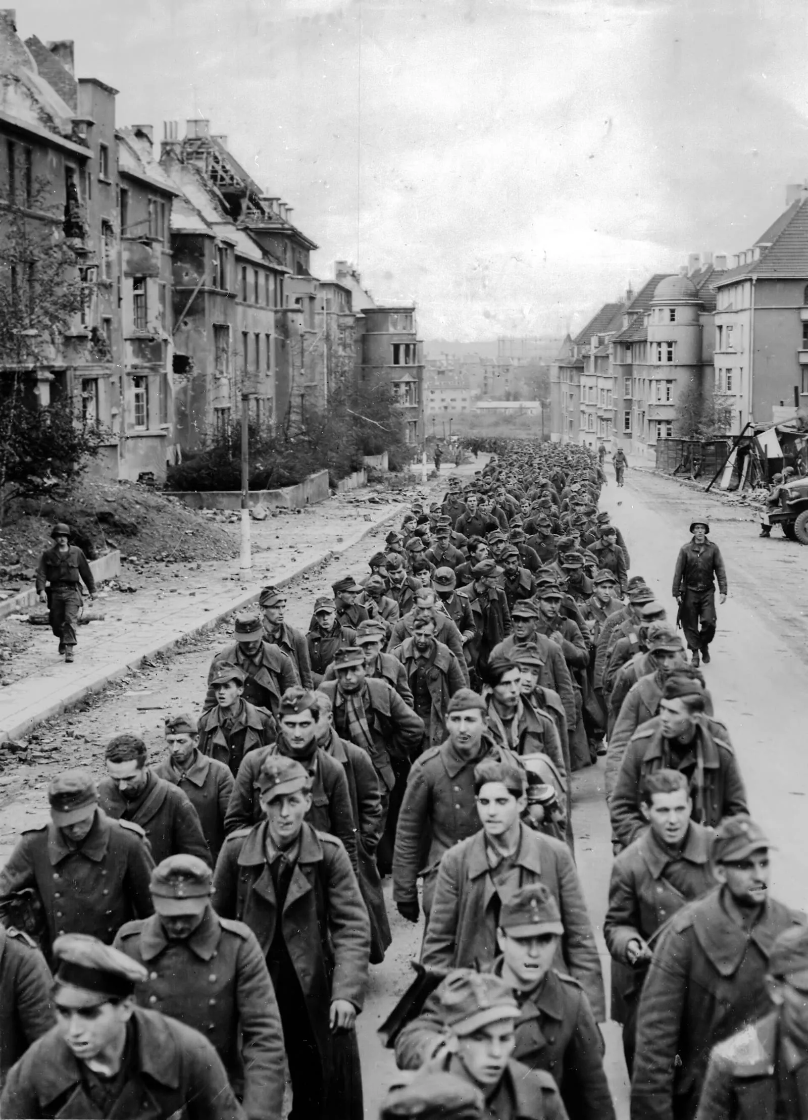 German prisoners captured at the fall of Aachen marching through the ruined streets of the city, October 1944.