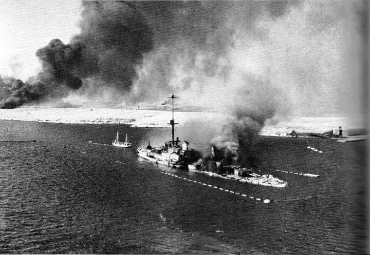 The Italian coastal defence ship San Giorgio, scuttled and burning at Tobruk after air attacks, 22 January 1941.